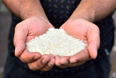 Midsection of man holding rice