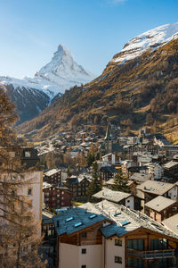 Aerial view of townscape and mountains against sky