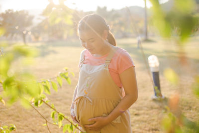 Pregnant woman standing in public park
