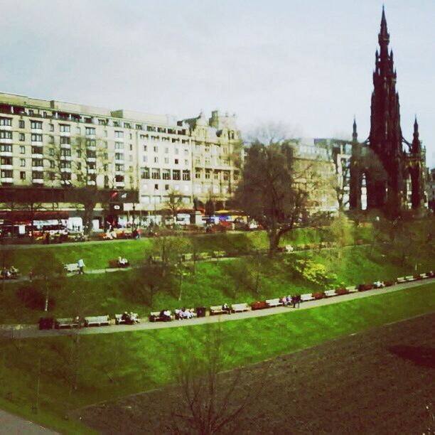 architecture, building exterior, built structure, grass, tree, sky, history, city, incidental people, green color, lawn, water, travel destinations, building, outdoors, day, famous place, travel, facade, church