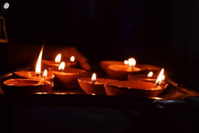 Close-up of lit candles burning in the dark