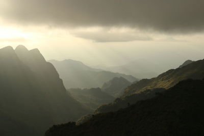 Scenic view of mountains against cloudy sky