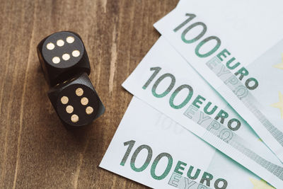 Close-up of paper currency and dice on table