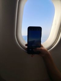 Man photographing through airplane window