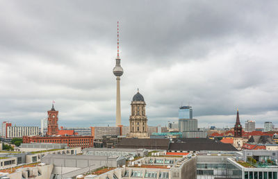 Buildings in city against cloudy sky