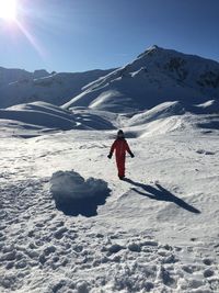 Full length of boy standing on snow covered mountain against sky