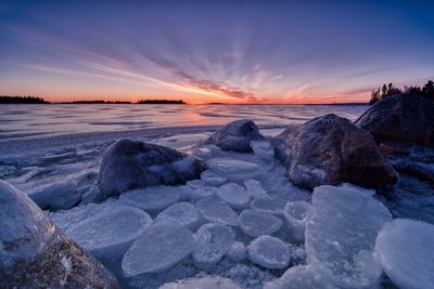 Scenic view of frozen lake against sky during sunset