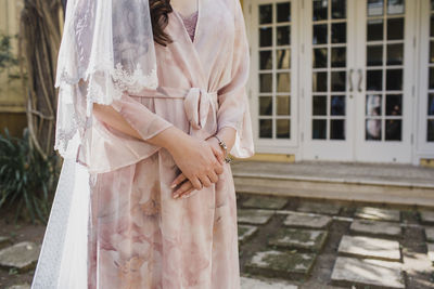 Midsection of woman standing by building on her wedding day