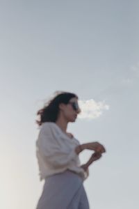 Side view of woman standing against sky