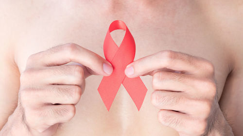 Midsection man holding red ribbon