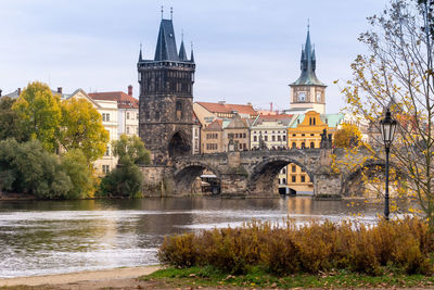 Arch bridge over river against buildings