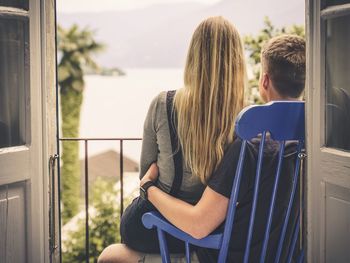 Rear view of couple sitting on railing