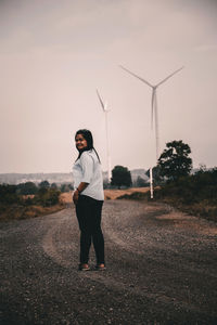 Portrait of woman standing on road against sky