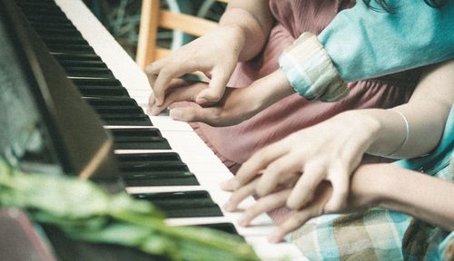 Midsection of child playing piano