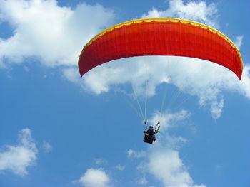 Low angle view of person paragliding against sky