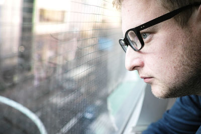 Close-up of thoughtful man looking through window