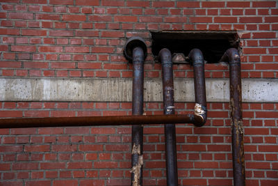 Rusty metal against brick wall