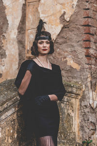 Young woman standing against wall