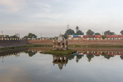 Reflection of building on lake against sky