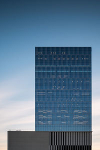Low angle view of modern building against blue sky