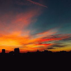 Silhouette city against sky during sunset