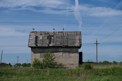 Traditional windmill on field against sky