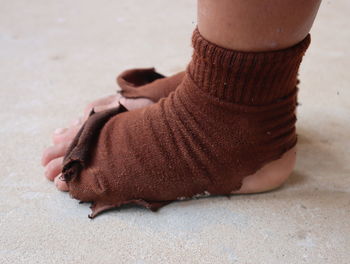 Low section of person wearing torn socks