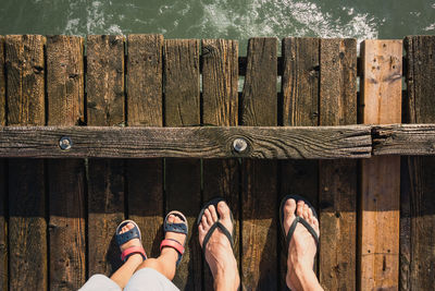 Low section of woman standing on wooden wall