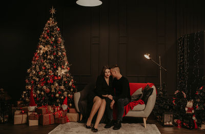 Couple using mobile phone while sitting at home