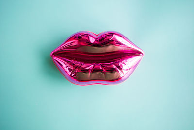 Directly above shot of pink glass against blue background