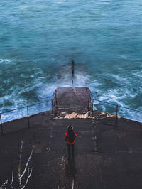 High angle view of man standing infront of sea