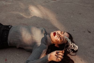 Woman with plant lying down on sand