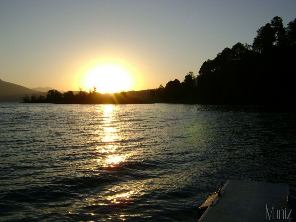 sunset, water, sun, scenics, tranquil scene, beauty in nature, tranquility, reflection, sunlight, rippled, waterfront, sea, orange color, silhouette, nature, sky, idyllic, lake, sunbeam, clear sky