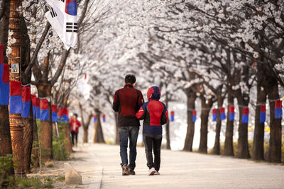 Rear view of people walking on footpath amidst cheongsachorongs