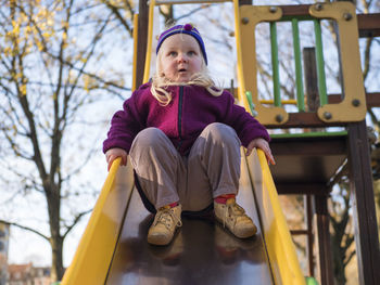 Cute girl playing on slide at playground