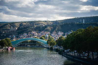 The bridge of peace over kura river by mountains against cloudy sky