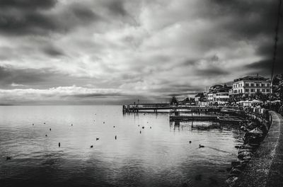 Pier on sea against cloudy sky