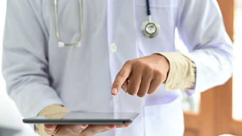 Midsection of man using mobile phone