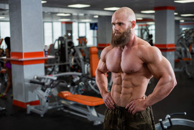 Portrait of shirtless man exercising in gym