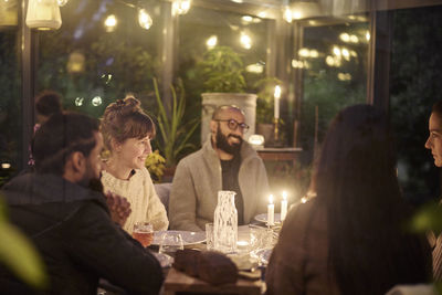 Happy friends having evening meal together