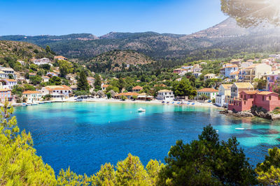 Scenic view of sea by townscape against sky