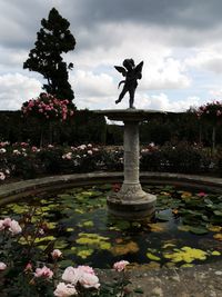 View of statue at park against cloudy sky