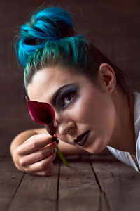 Close-up of a young woman with a flower on a blue background. beauty and fashion concept