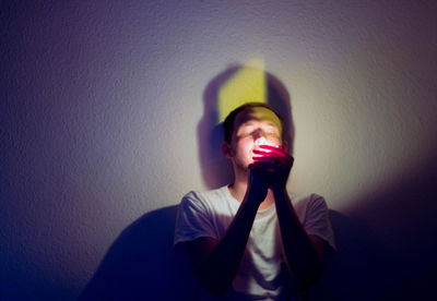 Young woman with shadow on wall