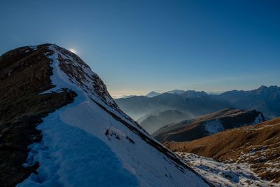 Scenic view of snowcapped mountains against clear blue sky