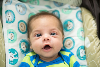 Portrait of cute baby lying on bed