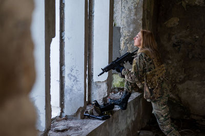 Side view of woman holding gun