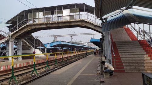 Train at railroad station in city against sky