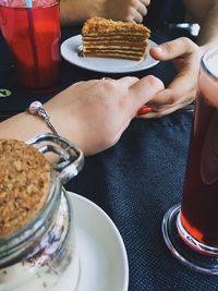 Cropped image of couple holding hands at dining table