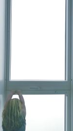 Rear view of woman on window